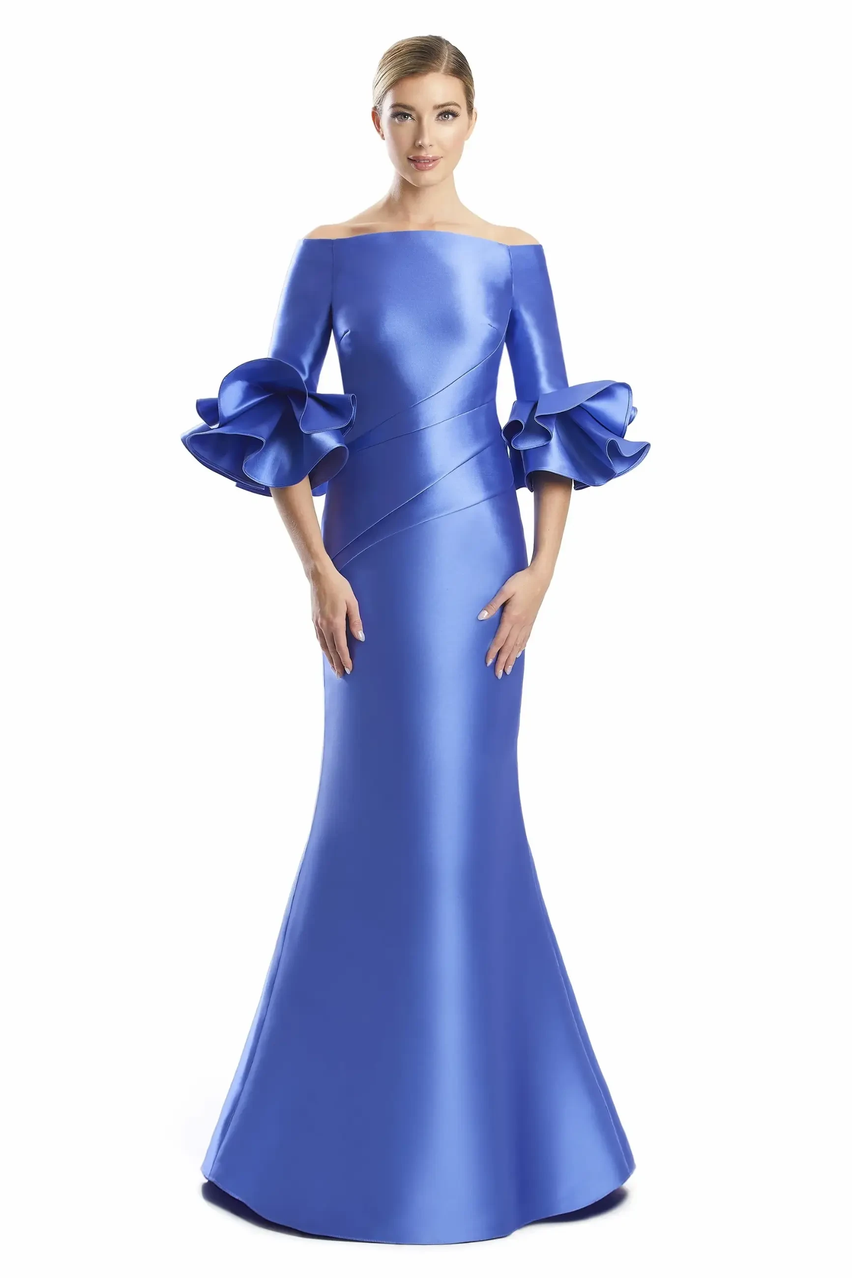Model is wearing a long mikado gown with a modified off-the-shoulder neckline, three-quarter ruffle sleeves, fit-and-flare silhouette, and buttons trailing down the back