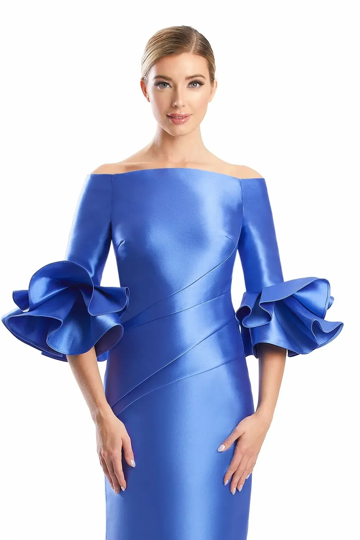 Model is wearing a long mikado gown with a modified off-the-shoulder neckline, three-quarter ruffle sleeves, fit-and-flare silhouette, and buttons trailing down the back