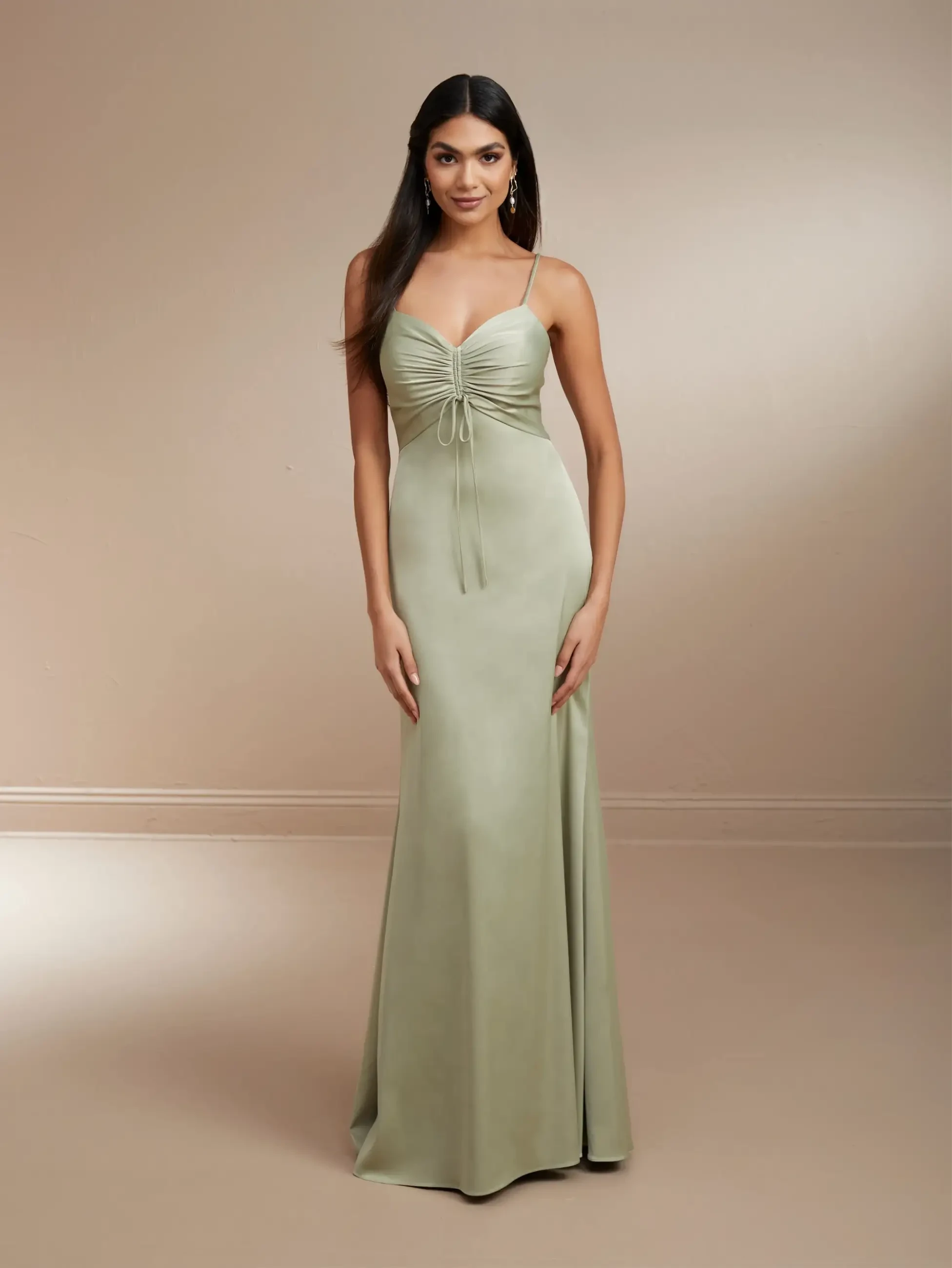 Model is wearing a silky sleeveless bridesmaid dress with a sheath silhouette