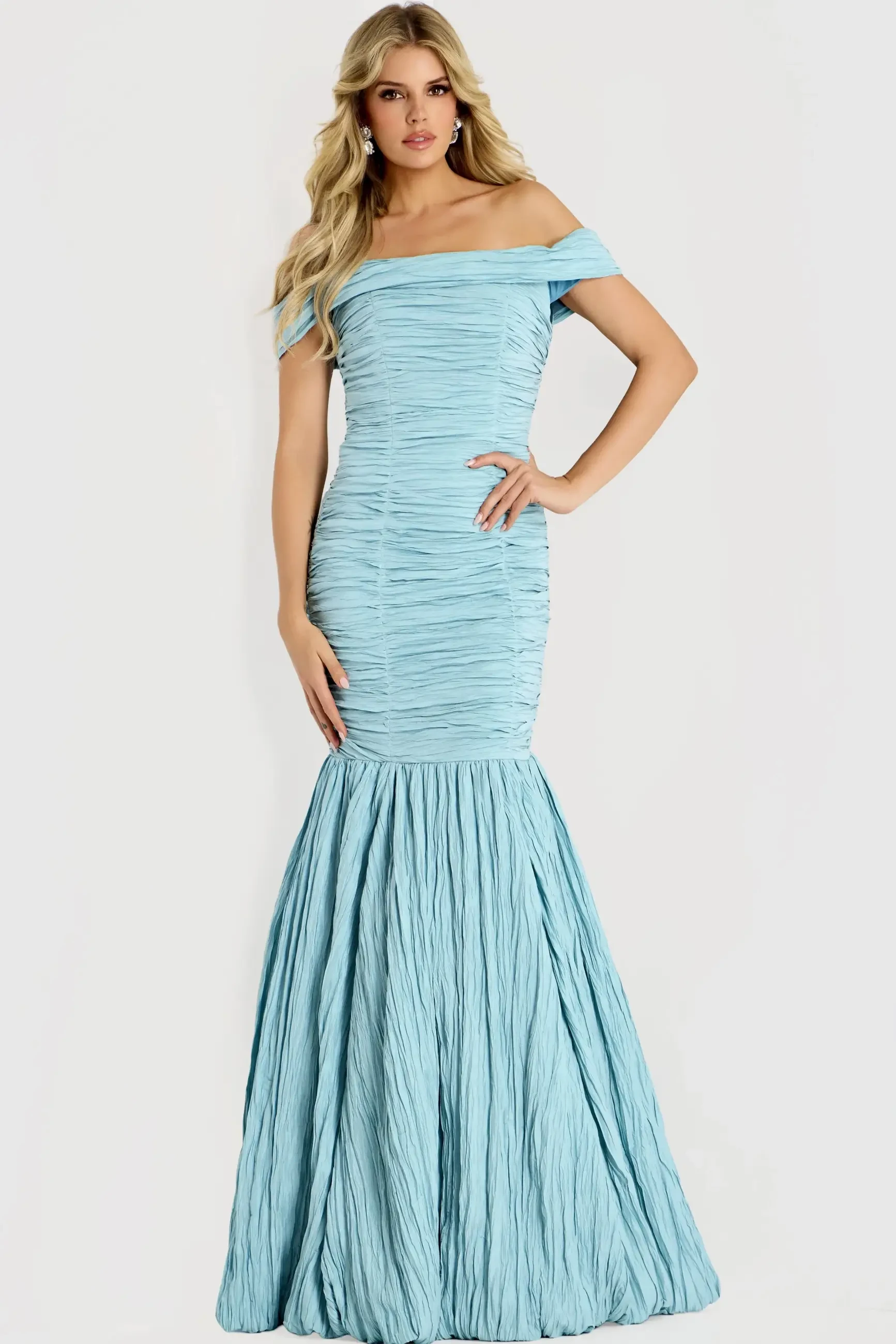 A model wearing a light blue off-the-shoulder gown with a fitted bodice and flared skirt.