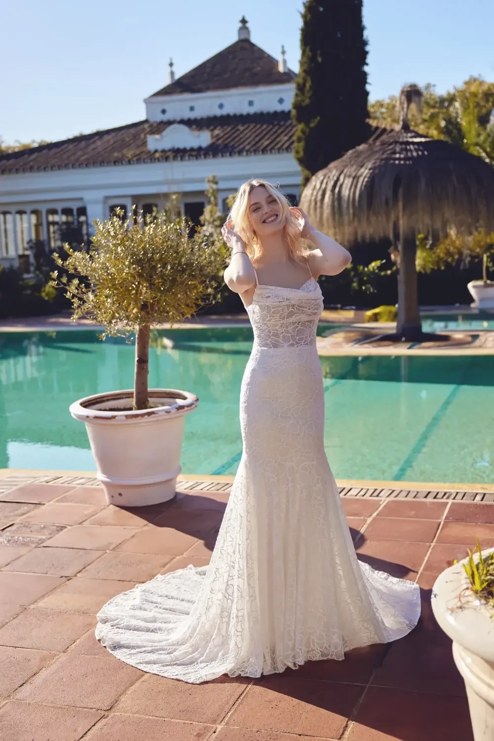 model is wearing a romantic lace bridal gown