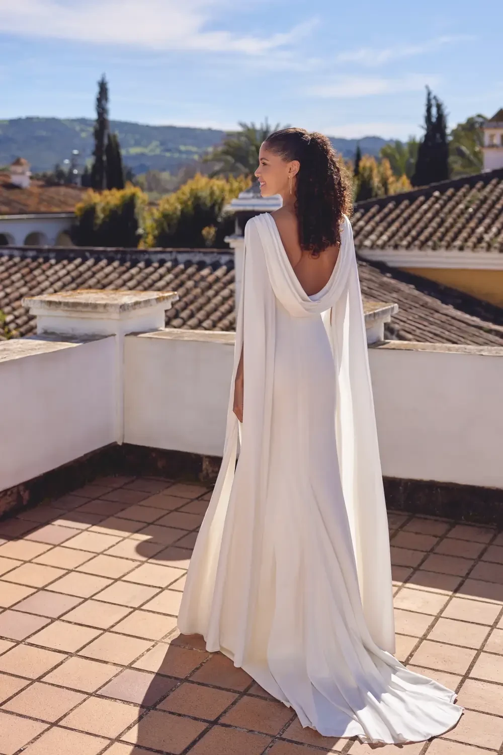 model is wearing a minimalist drapey wedding dress