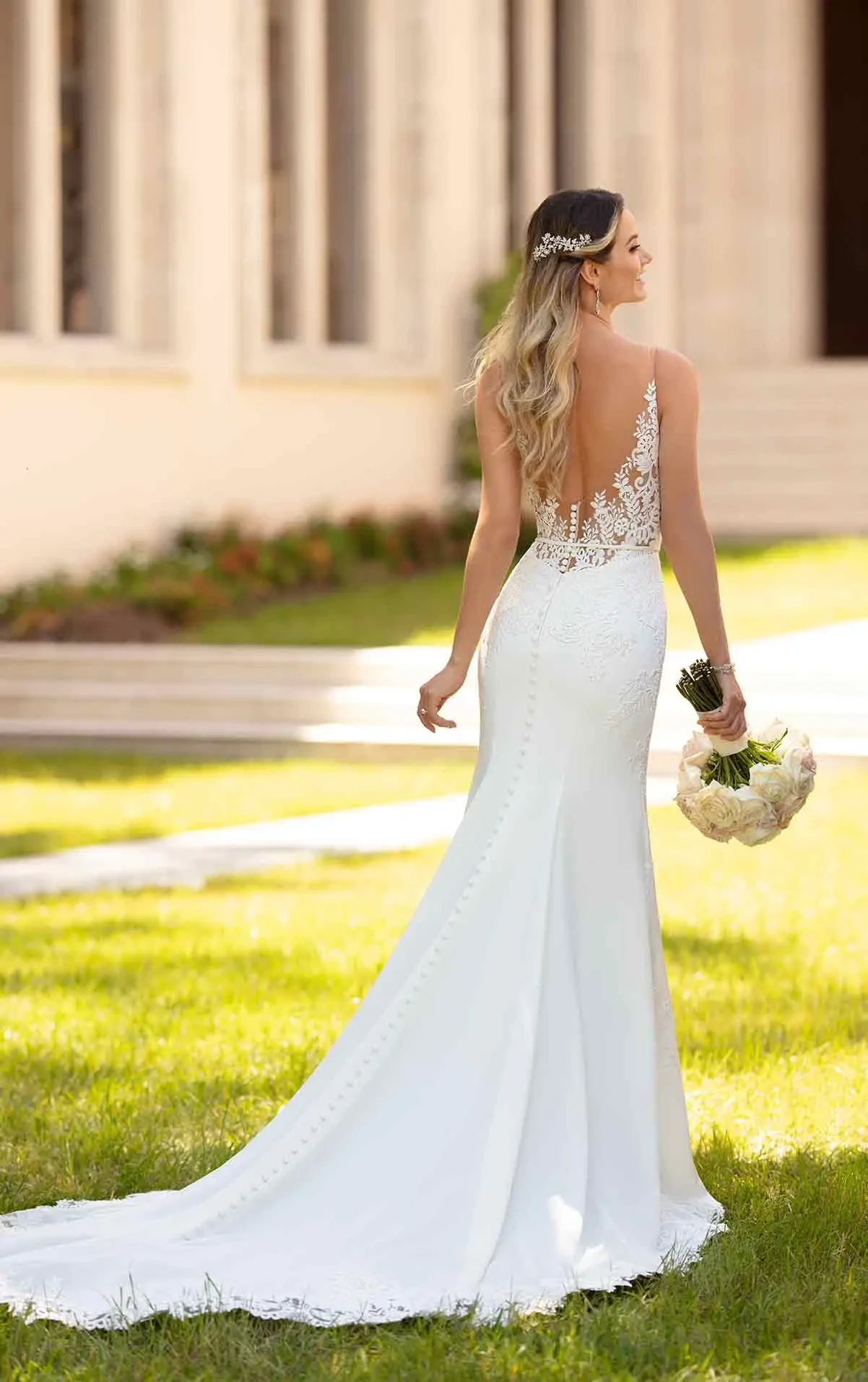 model is wearing a sleeveless fit and flare wedding dress