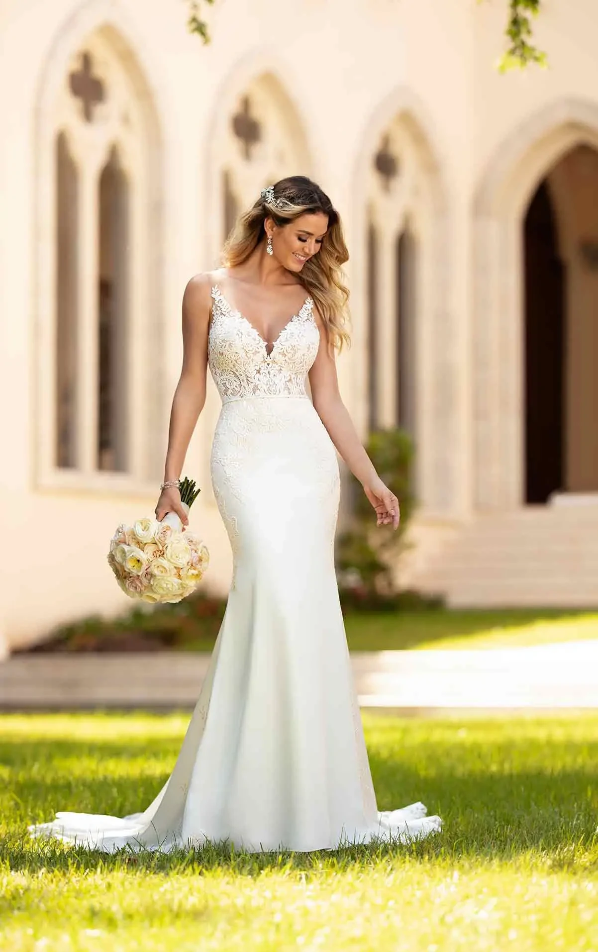 model is wearing a sleeveless fit and flare wedding dress