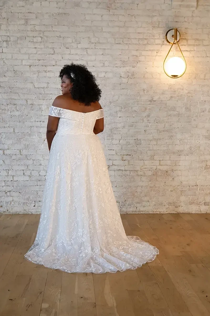 Model is wearing an off the shoulder plus size a-line bridal gown by stella york