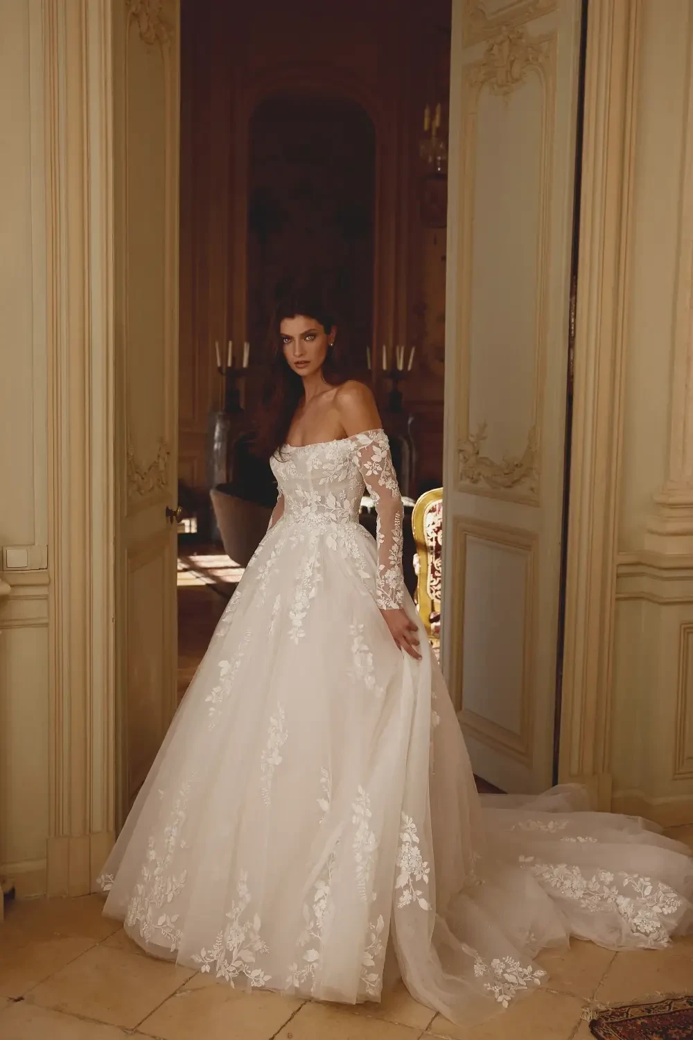 model is wearing an off the shoulder ball gown