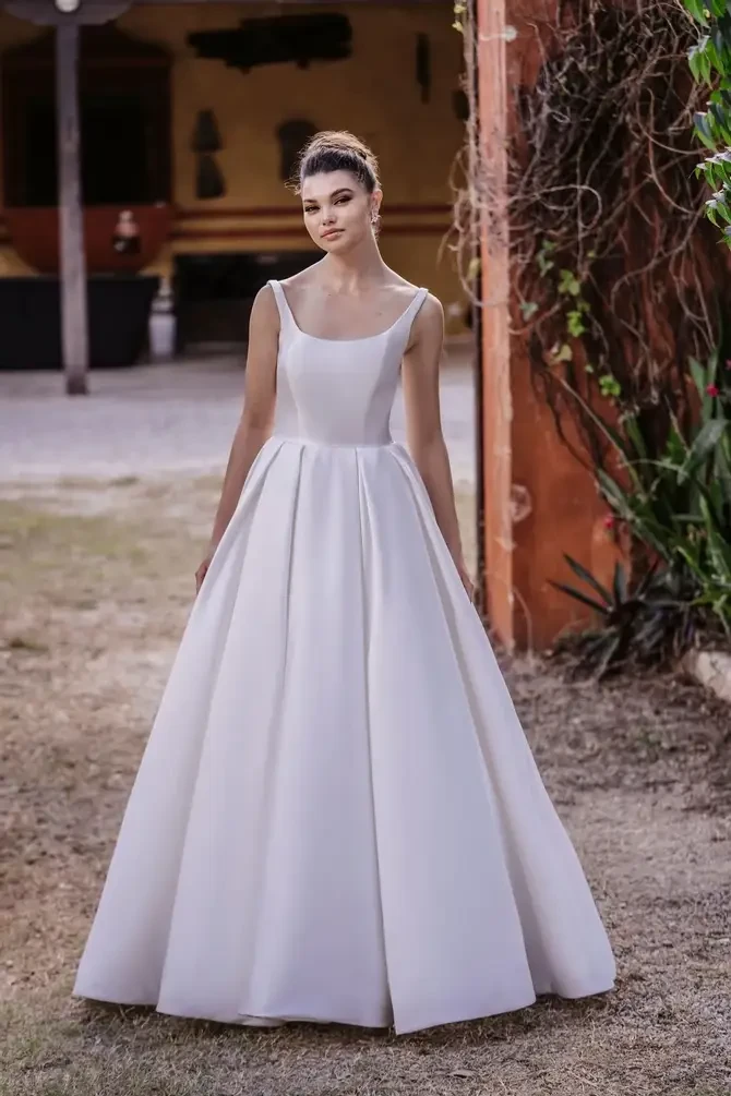 model is wearing a sleek sleeveless a-line wedding dress