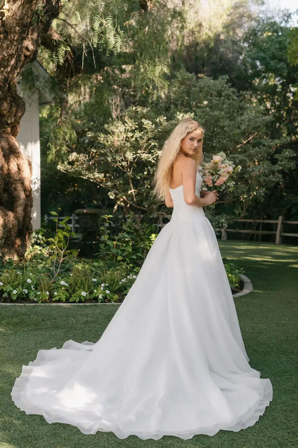 model is wearing a strapless drop waist bridal gown