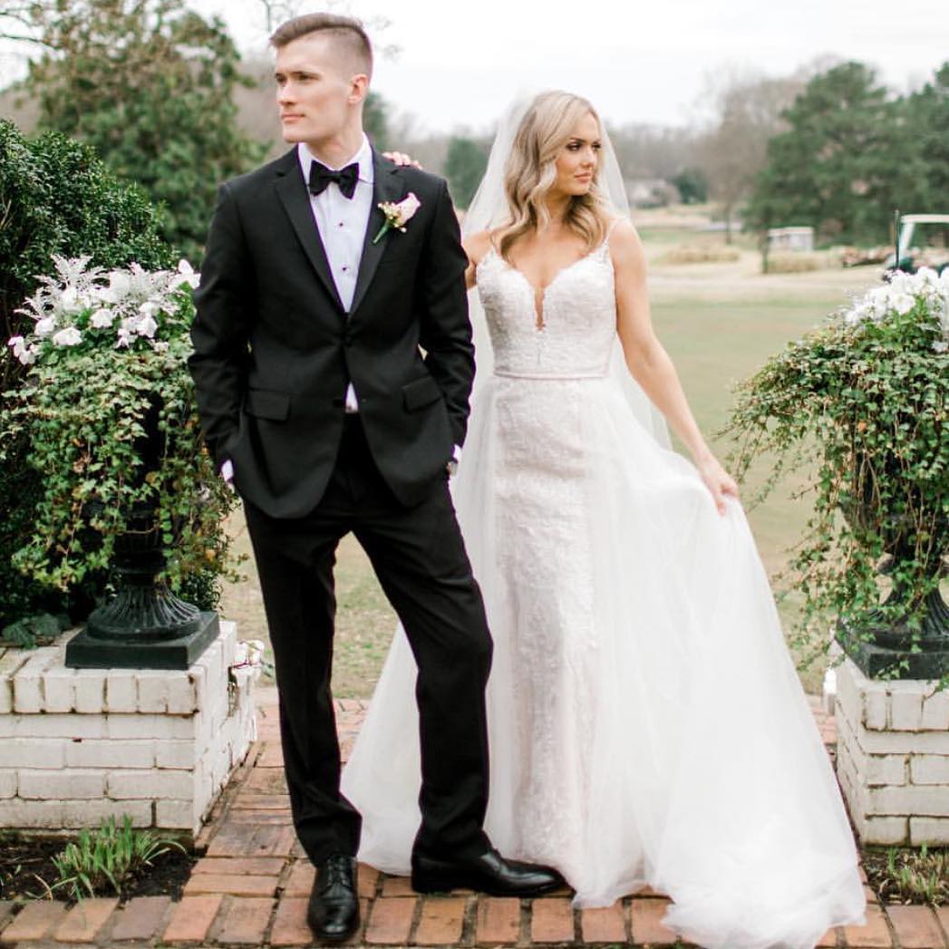 Сouple wearing a white gown and a black suit